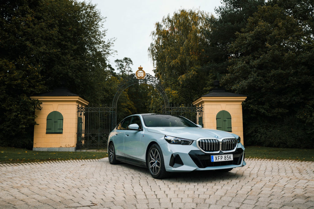 BMW-i5-Front-Sida-ljusblå-träd-bakgrund
